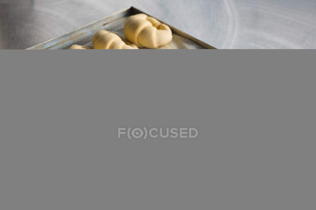 Rotoli di mezzaluna in un vassoio di metallo in panetteria — Foto stock