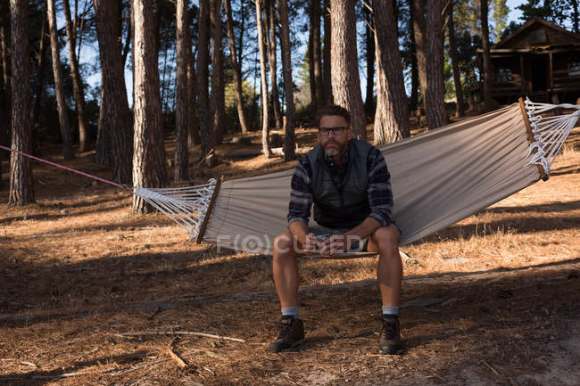 Nachdenklicher Mann mit Kaffeebecher entspannt auf Hängematte — Stockfoto
