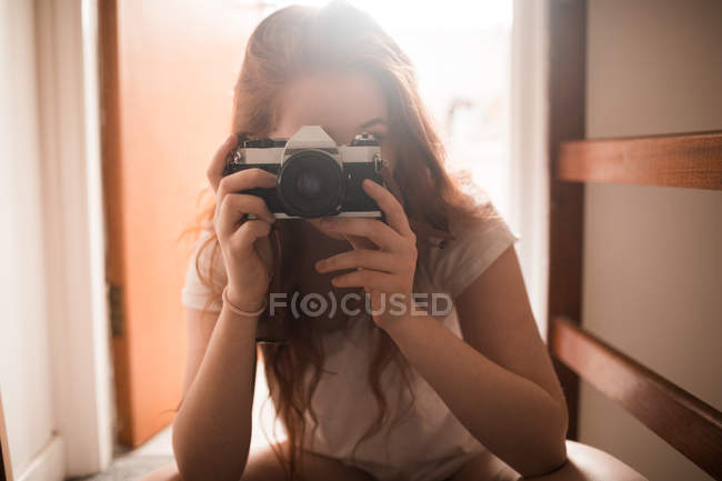 Femme cliquez sur la photo avec appareil photo à la maison — Photo de stock