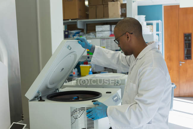 Scientist using a machine for experiment in lab — Stock Photo