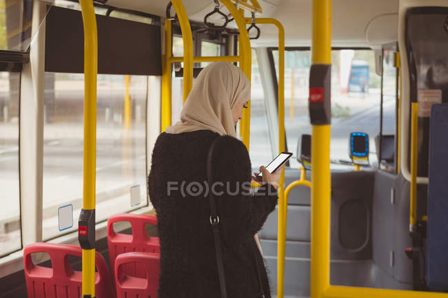 Belle femme hijab urbain en utilisant le téléphone mobile dans le bus — Photo de stock