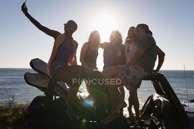 Groupe d'amis prenant selfie avec téléphone portable à la plage — Photo de stock