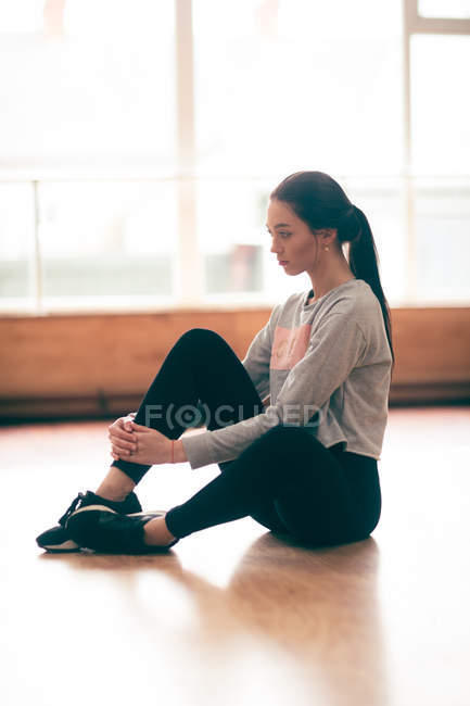 Thoughtful female dancer relaxing in dance studio — Stock Photo