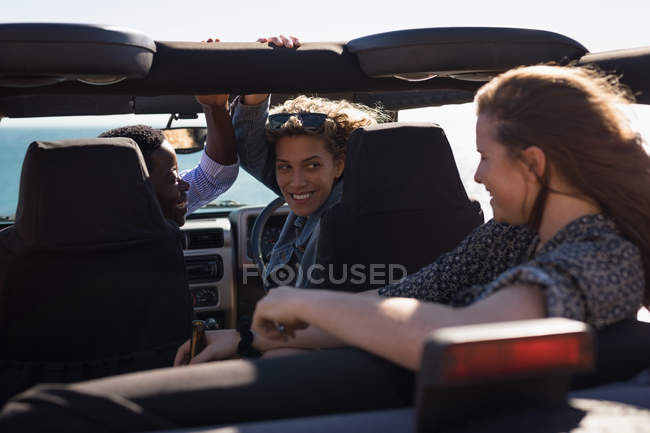 Female friends having fun in the jeep at beach — Stock Photo