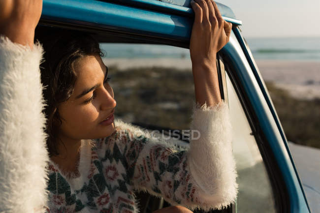 Femme se détendre dans une camionnette à la plage — Photo de stock