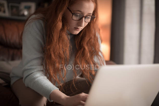 Жінка, використовуючи ноутбук у вітальні на дому — стокове фото