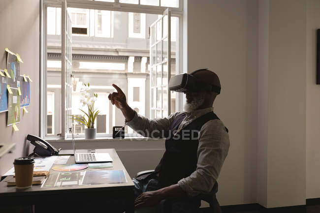 Designer gráfico sênior usando headset de realidade virtual no escritório — Fotografia de Stock