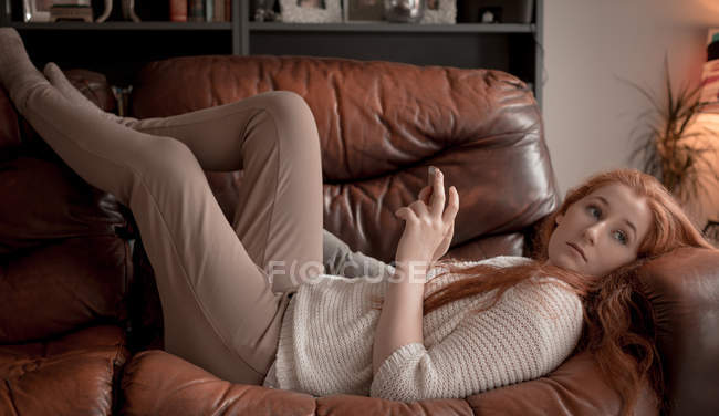 Женщина с мобильного телефона в гостиной на дому — стоковое фото
