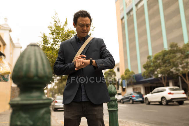 Businessman using his smartphone on street — Stock Photo