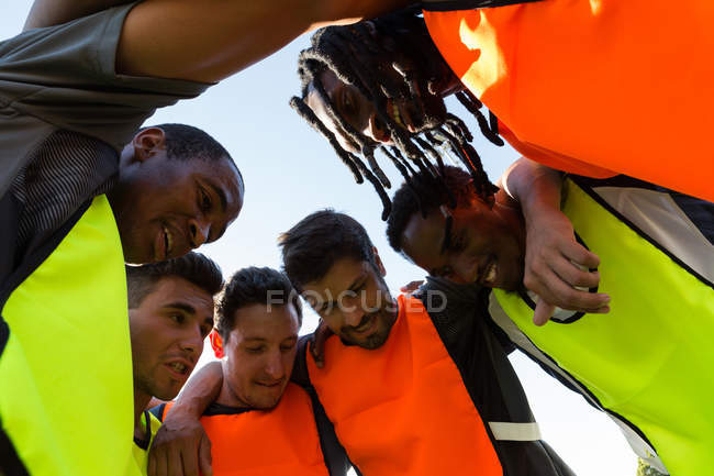 Счастливая футбольная команда шутит, стоя на поле — стоковое фото