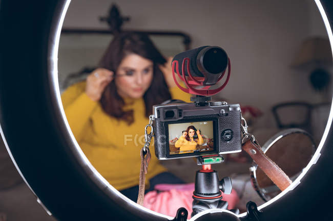 Enregistreur vidéo femme appliquant maquillage à la maison — Photo de stock