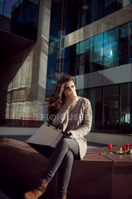 Jeune femme prenant un café dans la ville — Photo de stock