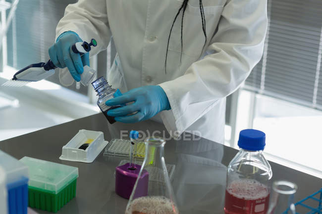 Sección intermedia del científico haciendo experimentos en laboratorio - foto de stock