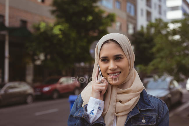 Belle femme hijab urbain parlant sur téléphone mobile à la rue — Photo de stock