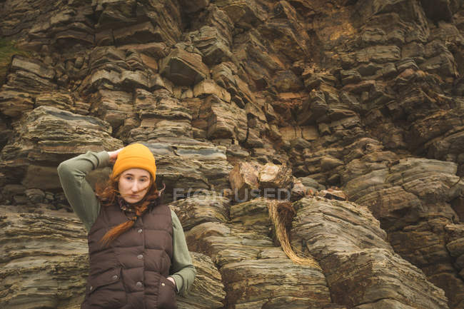 Hermosa excursionista femenina apoyada contra la roca - foto de stock