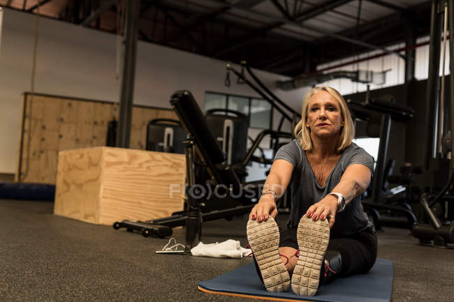 Недосвідчена жінка виконує розтяжку вправи в спортзалі — стокове фото