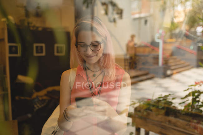 Молода жінка використовує мобільний телефон у кав'ярні — стокове фото