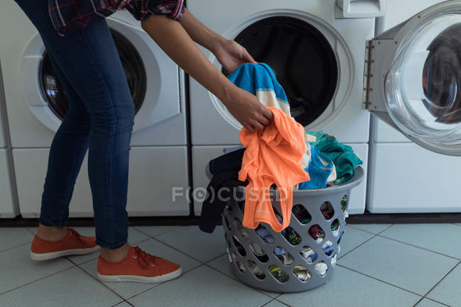 Gros plan de la femme faisant la lessive dans la laverie automatique — Photo de stock