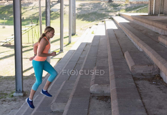 Молодая спортсменка разогревается на спортивной площадке — стоковое фото
