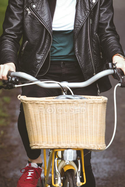 Mid section of woman in jacket riding cycle — Stock Photo