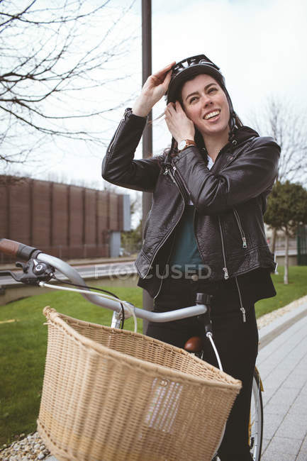 Belle femme à vélo portant un casque — Photo de stock