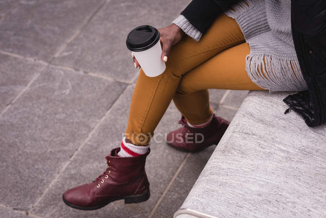 Low section of woman having coffee in city street — Stock Photo