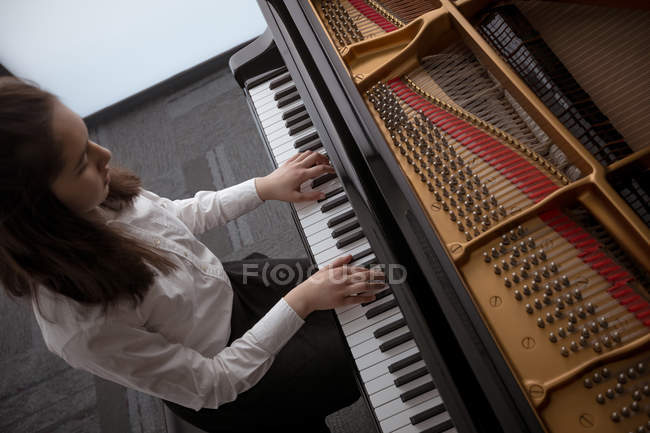 Adorable écolière jouant du piano à l'école de musique — Photo de stock