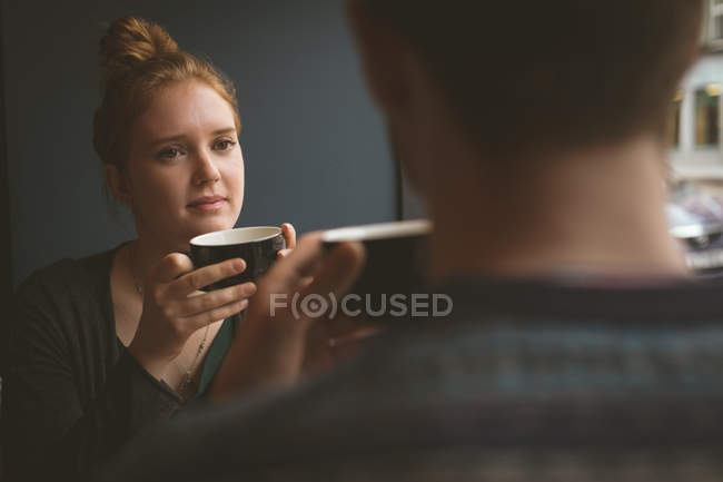Close-up de mulher bonita falando com um homem no café — Fotografia de Stock