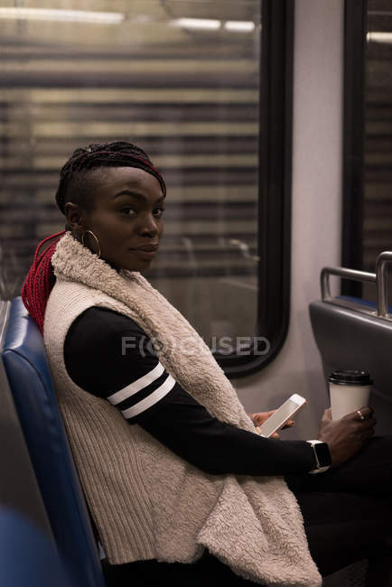 Jovem usando telefone celular enquanto viaja no trem — Fotografia de Stock
