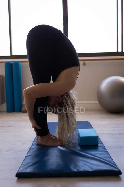 Femme effectuant des exercices d'étirement dans un studio de fitness — Photo de stock