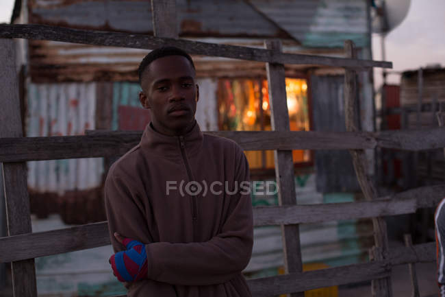 Portrait of male boxer standing with arms crossed at dusk — Stock Photo