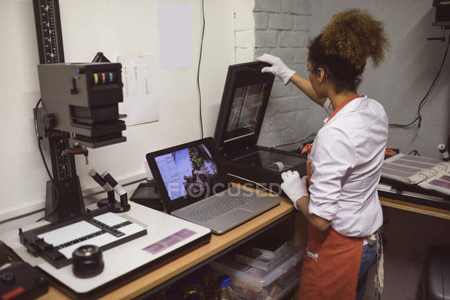 Fotografo femminile che utilizza lo scanner fotografico in studio fotografico — Foto stock