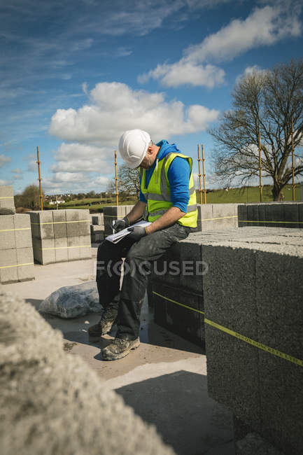 Engineer looking at his notepad at the construction site on a sunny day — Stock Photo