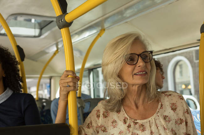 Pensativa mujer mayor viajando en el autobús - foto de stock