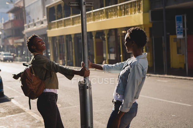 Gemelos hermanos divirtiéndose en la calle de la ciudad - foto de stock