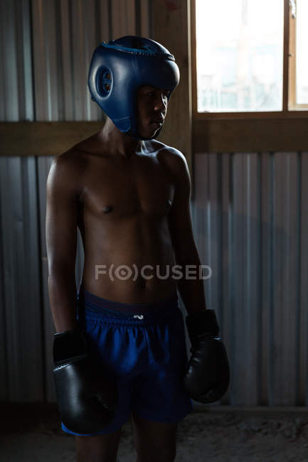 Boxeur masculin réfléchi debout à la salle de fitness — Photo de stock