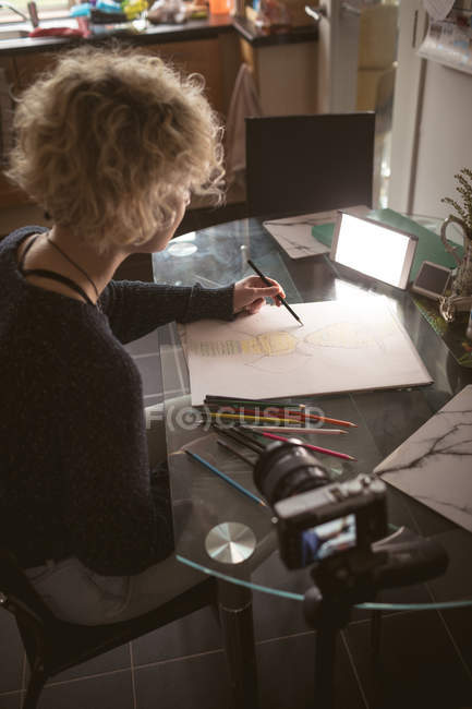 Женщина-блоггер рисует скетч дома — стоковое фото