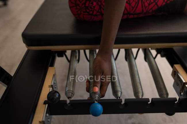 Femme faisant de l'exercice sur une machine à étirer dans un studio de fitness — Photo de stock