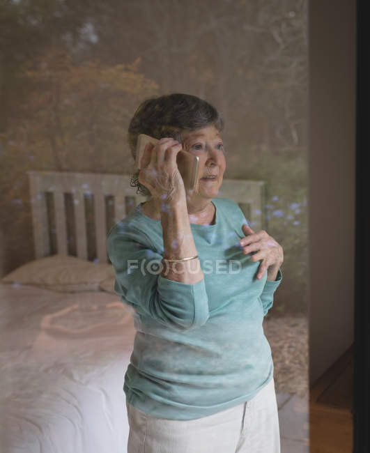 Seniorin telefoniert zu Hause mit Handy — Stockfoto