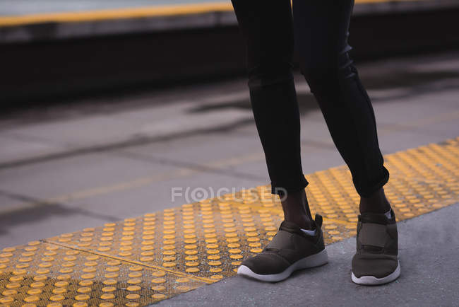 Low section of woman standing at railway station — Stock Photo