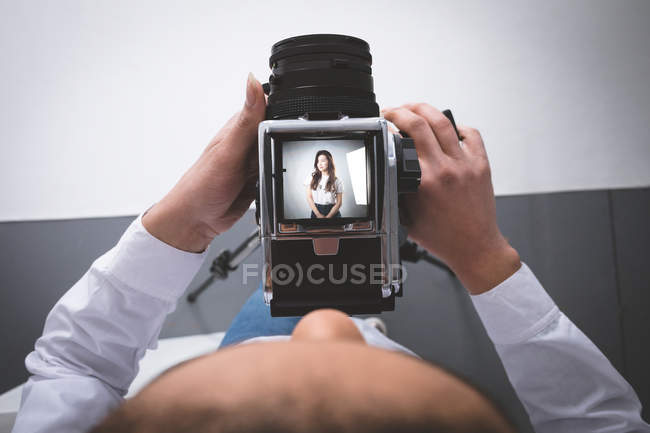 Fotografia femminile cliccando foto di modella in studio fotografico — Foto stock