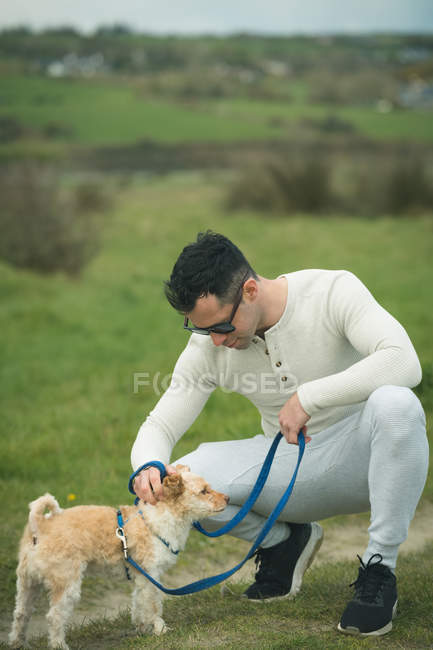 Carinhoso homem acariciando seu cão — Fotografia de Stock