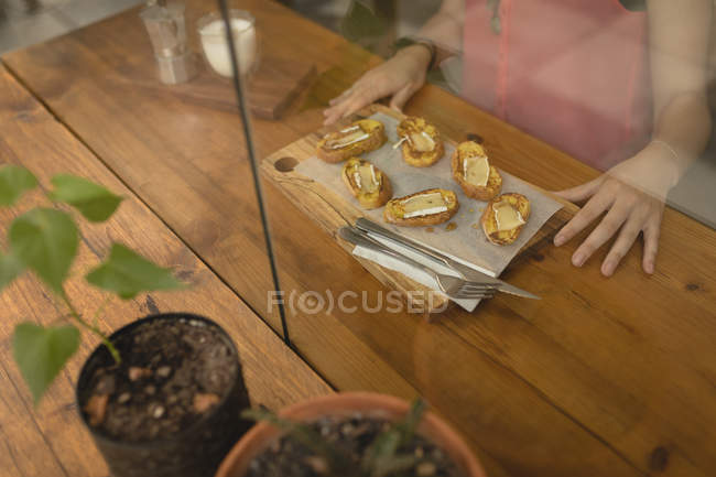 Brot mit Käse, serviert auf einem Holzbrett in einem Café — Stockfoto