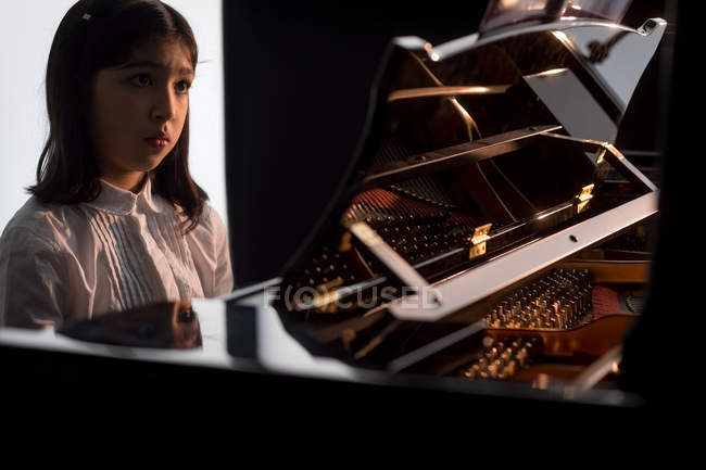 Entzückendes Schulmädchen spielt Klavier in der Musikschule — Stockfoto
