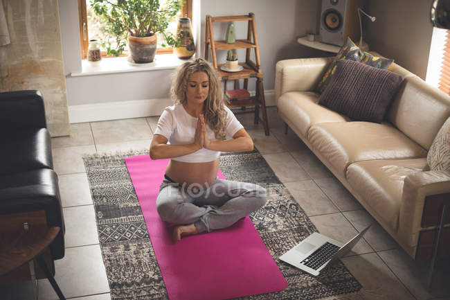 Pregnant woman exercising in living room at home — Stock Photo