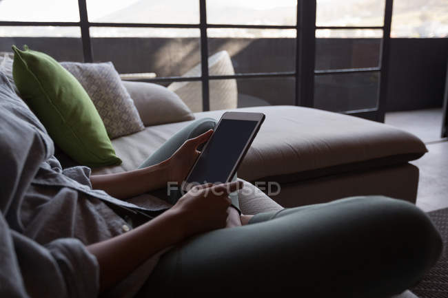 Seção média de mulher usando laptop na sala de estar em casa — Fotografia de Stock