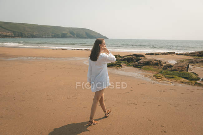 Mulher bonita andando na praia em um dia ensolarado — Fotografia de Stock