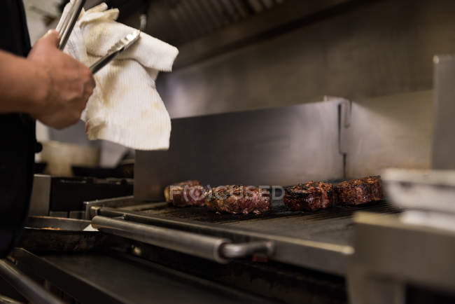 Male chef preparing food in kitchen at restaurant — Stock Photo