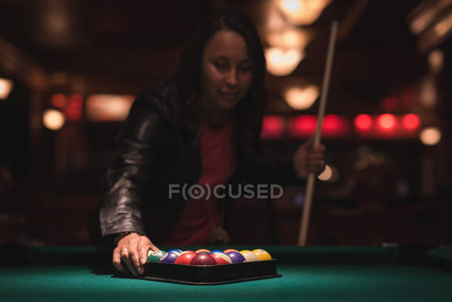 Frau arrangiert Snookerbälle im Dreiecksgestell in Nachtclub — Stockfoto