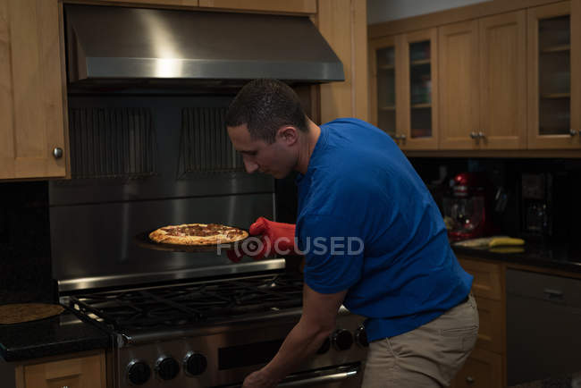 Man preparing pizza in the kitchen at home — Stock Photo